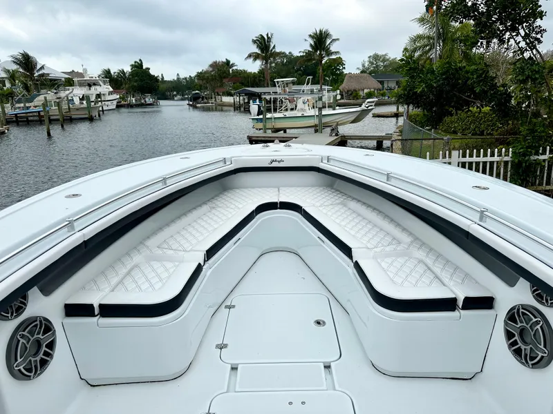Slide: The Image of 2024 Yellowfin 36 boat with spacious seating in a scenic marina. - 18