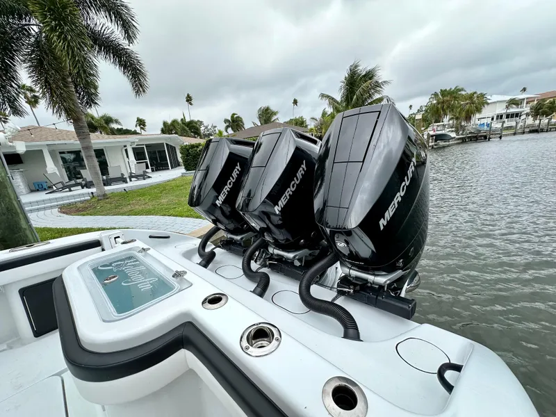 Slide: The Image of 2024 Yellowfin 36 boat with triple Mercury outboard engines docked by waterfront homes. - 19