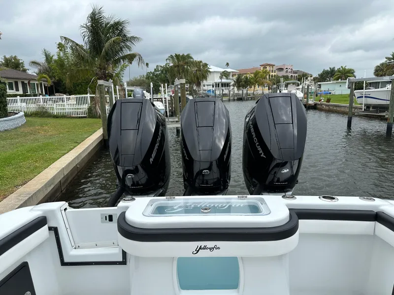 Slide: The Image of 2024 Yellowfin 36 boat with triple Mercury outboard engines docked in a canal. - 20