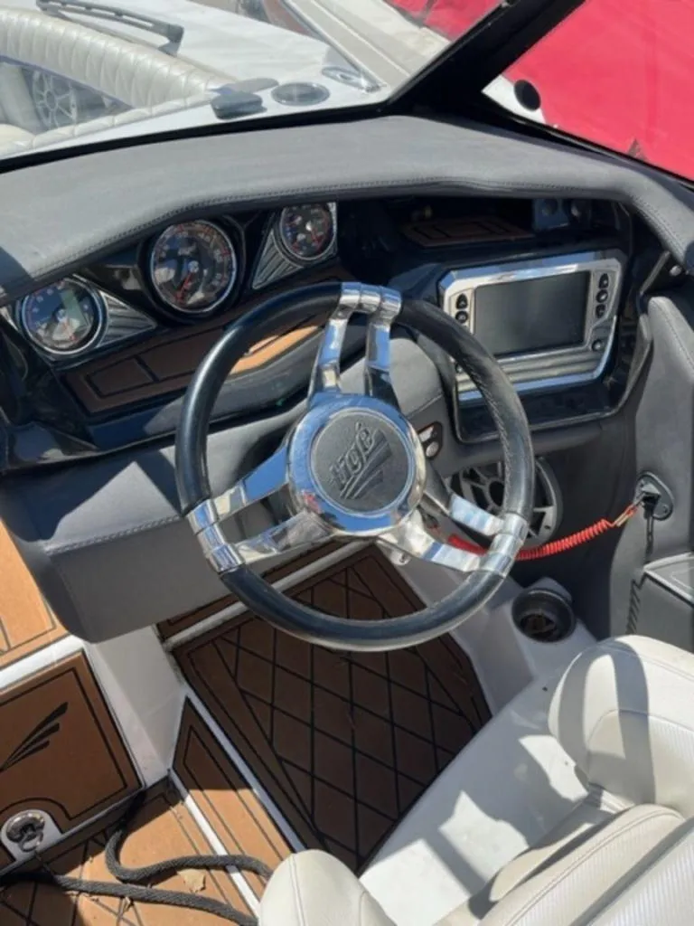 Slide: The Image of 2016 Tigé RZX boat dashboard with steering wheel and control panel. - 10
