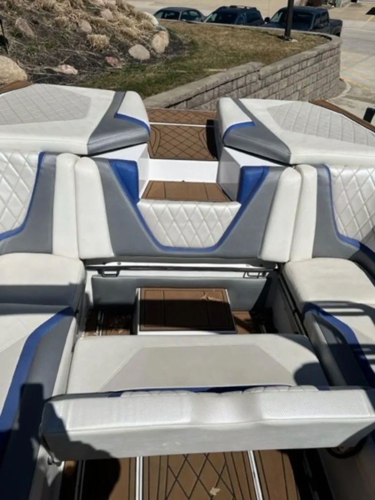 Slide: The Image of 2016 Tigé RZX boat interior with white and blue cushioned seating. - 8
