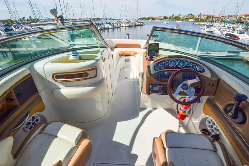 Slide: The Image of 2014 Crownline Eclipse E6 boat interior with dashboard and seating, docked at a marina. - 12
