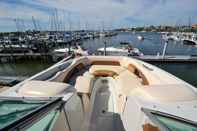 Slide: The Image of 2014 Crownline Eclipse E6 boat with spacious seating at a marina. - 13