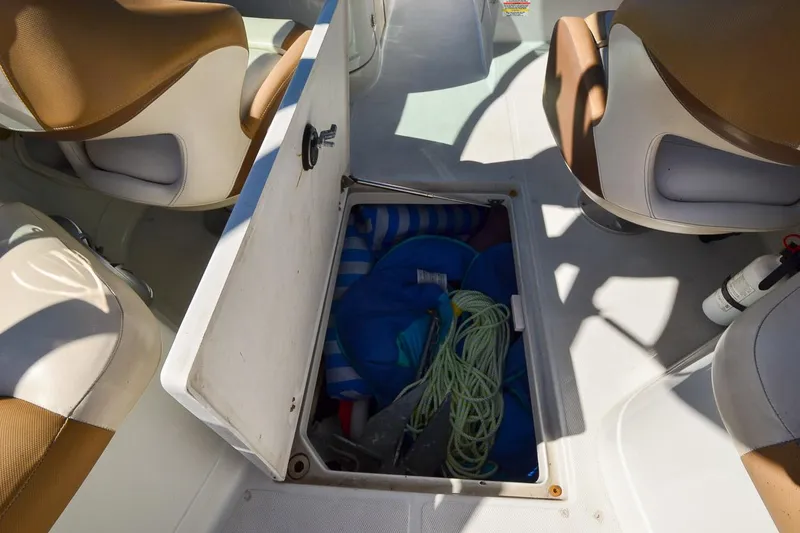 Slide: The Image of 2014 Crownline Eclipse E6 boat storage compartment with ropes and equipment. - 22