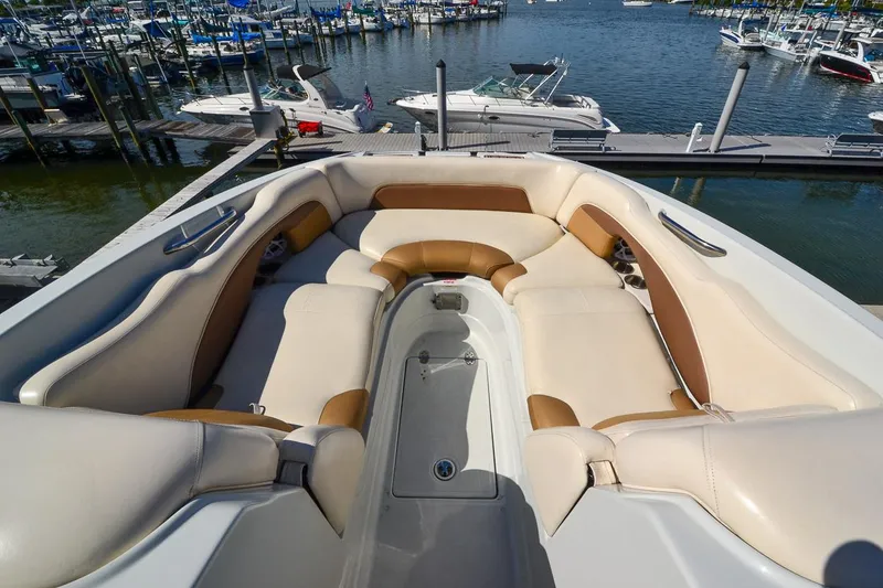 Slide: The Image of 2014 Crownline Eclipse E6 boat with spacious seating at a marina. - 24