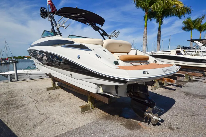 Slide: The Image of 2014 Crownline Eclipse E6 boat docked at a marina with palm trees. - 3