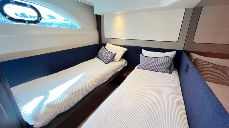 Slide: The Image of Interior of 2019 Princess F62 yacht with twin beds and striped pillows. - 26