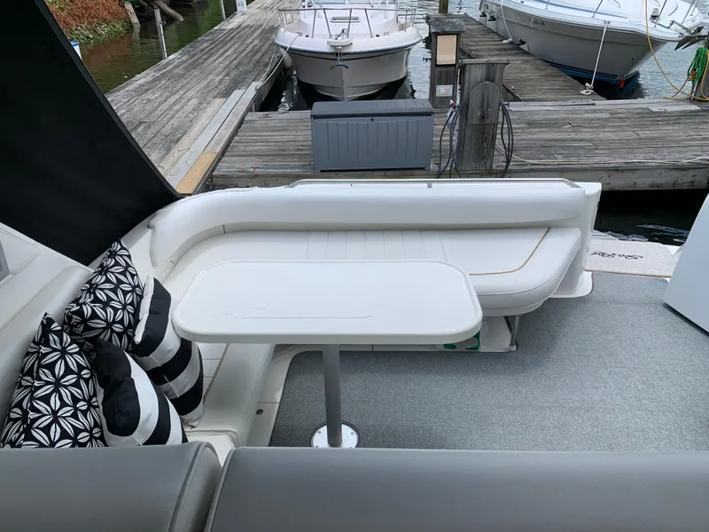 Slide: The Image of 1997 Sea Ray 370 Sundancer boat interior with seating and table at dock. - 12