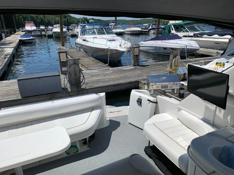 Slide: The Image of 1997 Sea Ray 370 Sundancer at marina dock, interior view with seating and TV. - 14