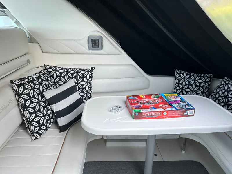 Slide: The Image of Interior of 1997 Sea Ray 370 Sundancer with table, cushions, and board games. - 16