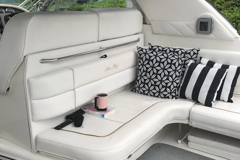 Slide: The Image of Interior seating of a 1997 Sea Ray 370 Sundancer with decorative pillows. - 17