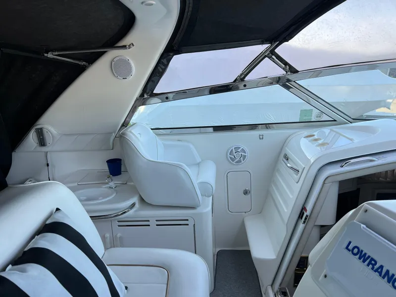 Slide: The Image of Interior of 1997 Sea Ray 370 Sundancer boat with white seating and Lowrance equipment. - 23