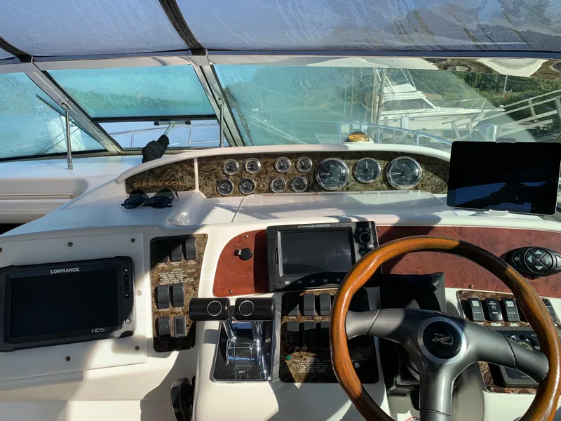 Slide: The Image of 1997 Sea Ray 370 Sundancer helm with navigation instruments and wooden steering wheel. - 29