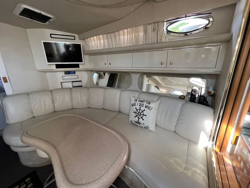 Slide: The Image of Interior of a 1997 Sea Ray 370 Sundancer with white leather seating and a mounted TV. - 47