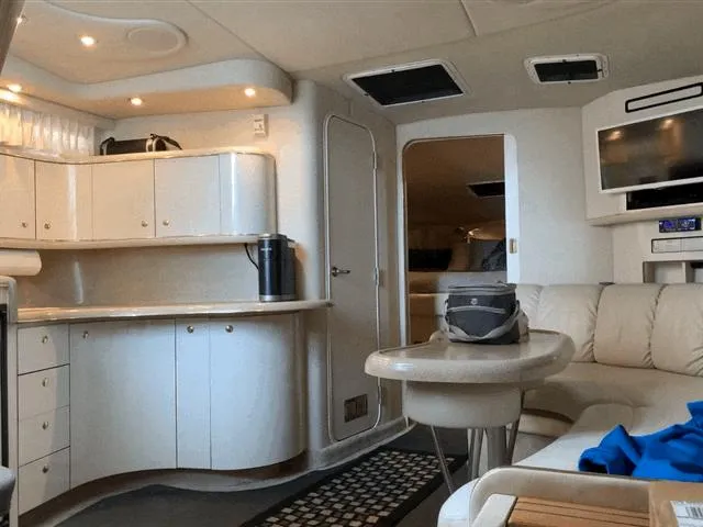 Slide: The Image of Interior of 1997 Sea Ray 370 Sundancer yacht with modern kitchen and cozy seating area. - 49