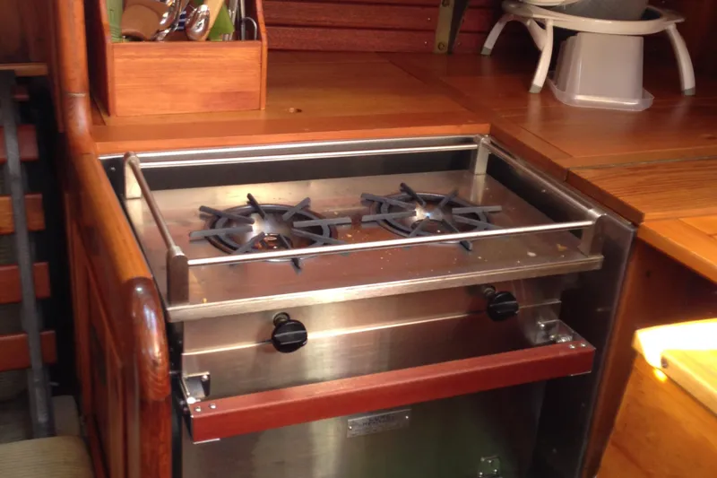Slide: The Image of 1955 Concordia Yawl interior with a two-burner stainless steel stove in a wooden galley. - 11