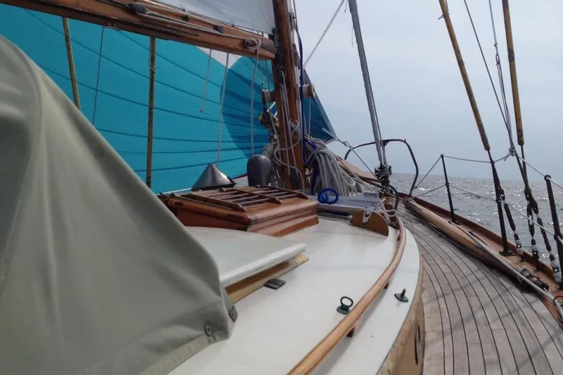 Slide: The Image of 1955 Concordia Yawl sailboat deck with wooden details and blue sail. - 17