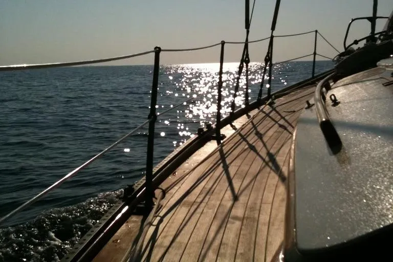Slide: The Image of 1955 Concordia Yawl sailing on sunlit sea, showcasing wooden deck and sparkling water. - 20