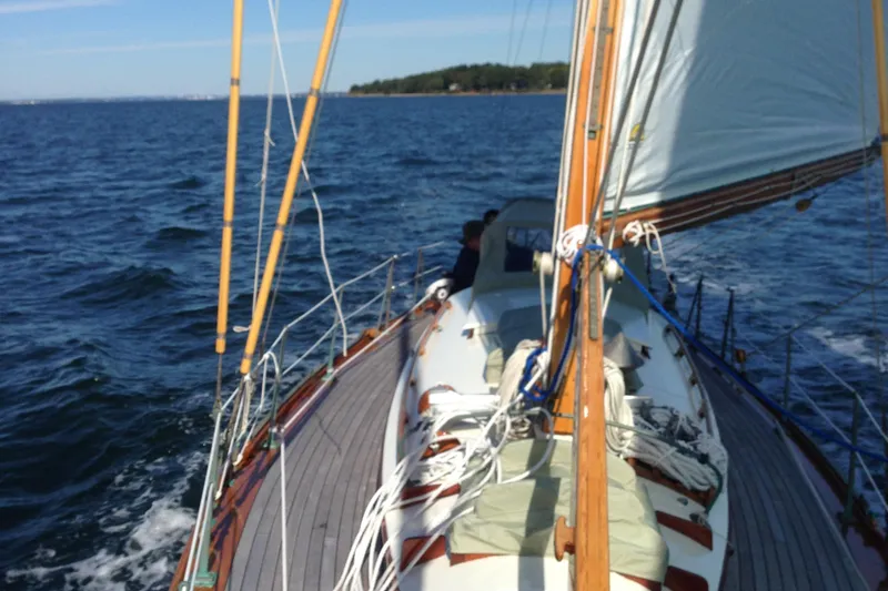 Slide: The Image of 1955 Concordia Yawl sailing on open water, showcasing classic wooden deck and rigging. - 25