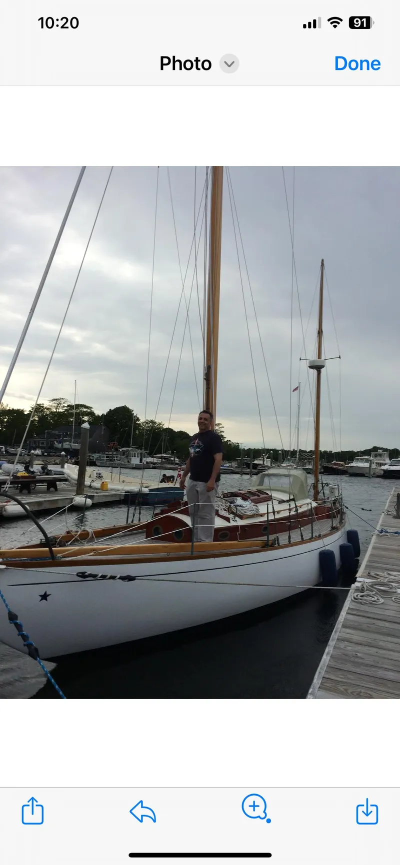 Slide: The Image of 1955 Concordia Yawl (Hull #33) docked at marina with person on deck. - 28