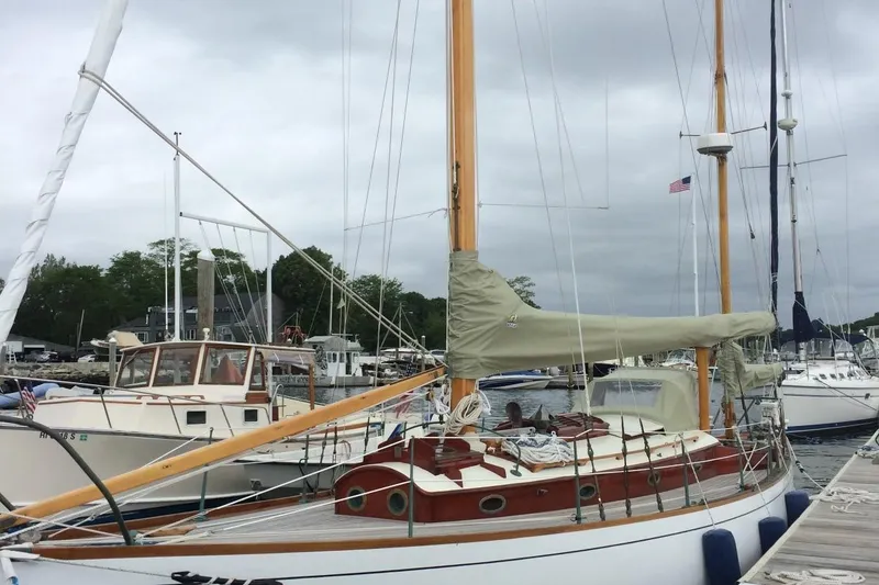 Slide: The Image of 1955 Concordia Yawl sailboat docked at a marina, featuring classic wooden design. - 29
