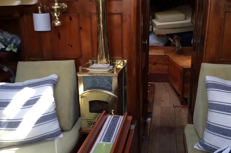 Slide: The Image of Interior of 1955 Concordia Yawl, featuring wood paneling and a brass stove. - 3