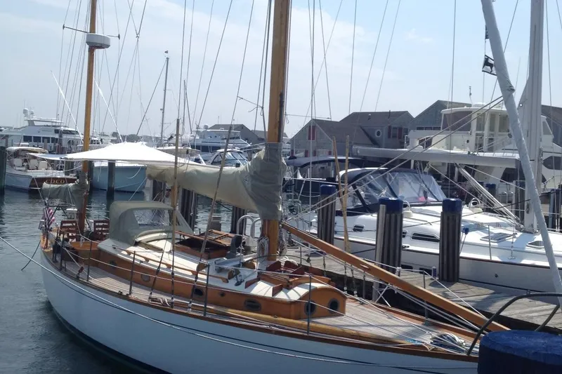 Slide: The Image of 1955 Concordia Yawl (Hull #33) docked at a marina, showcasing classic wooden design. - 30