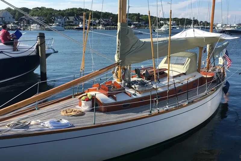 Slide: The Image of 1955 Concordia Yawl (Hull #33) docked, showcasing classic wooden design and elegant sails. - 32