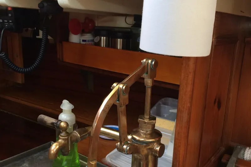 Slide: The Image of Interior of 1955 Concordia Yawl, featuring vintage brass pump and wooden cabinetry. - 5