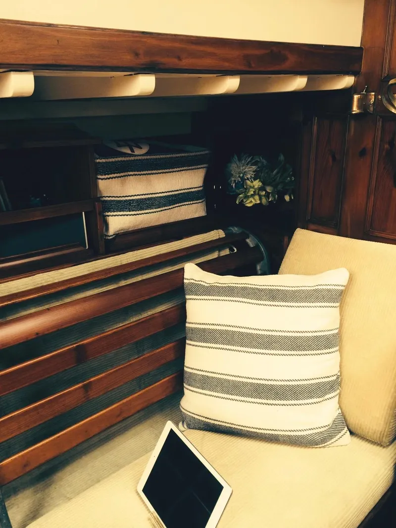 Slide: The Image of Interior of 1955 Concordia Yawl, featuring striped cushions and wooden accents. - 6