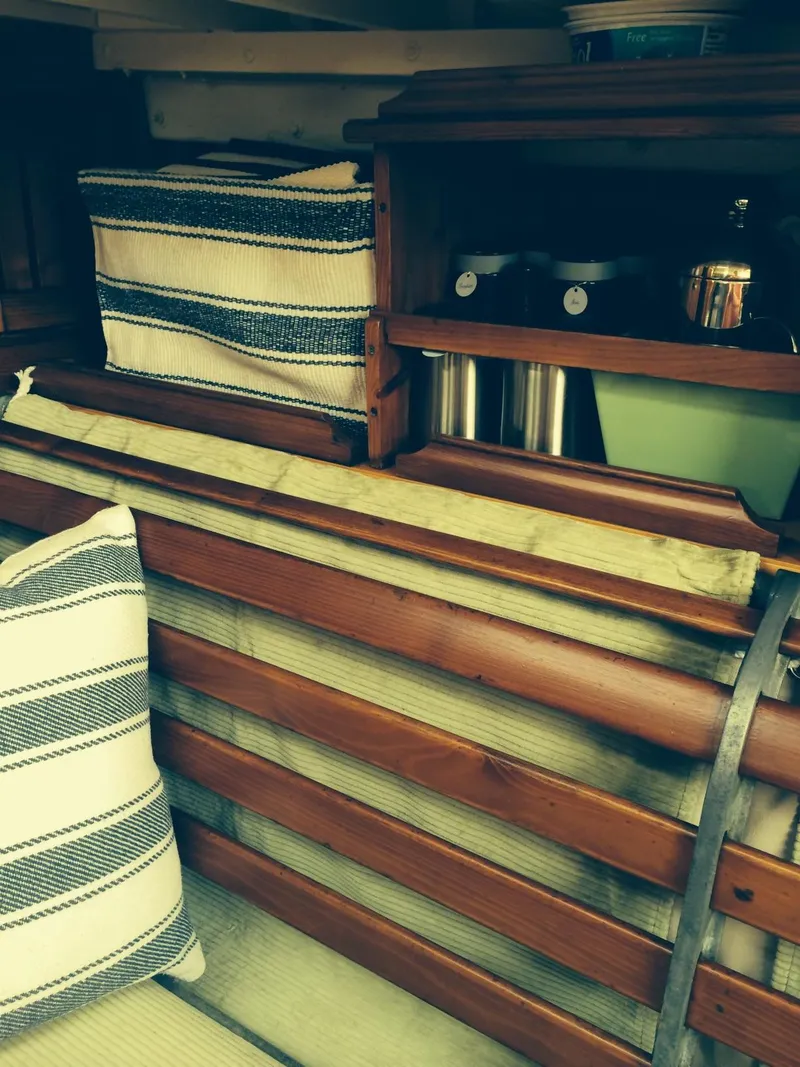 Slide: The Image of Interior of 1955 Concordia Yawl, featuring wooden shelves and striped cushions. - 7