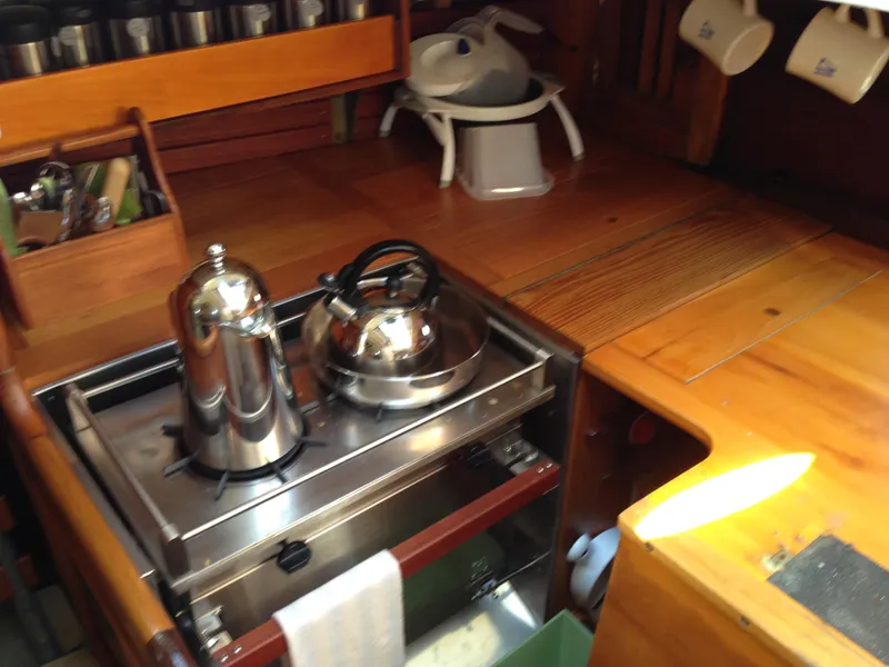 Slide: The Image of Compact galley kitchen on 1955 Concordia Yawl, featuring stainless steel kettle and coffee pot. - 8