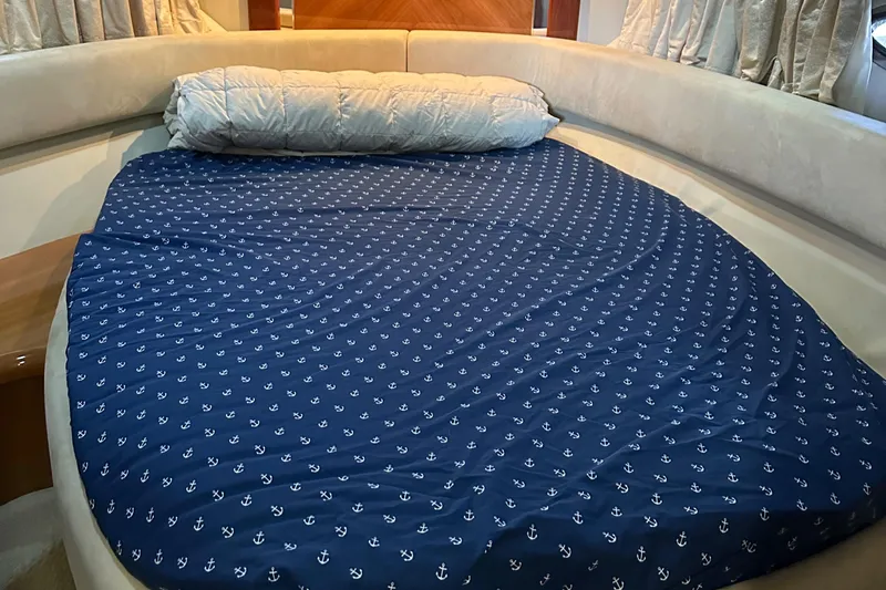 Slide: The Image of Sunseeker 350 2005 boat interior with a cozy bed and anchor-patterned bedding. - 15