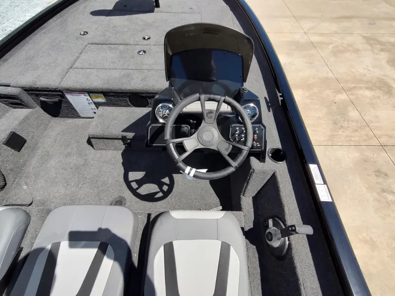 Slide: The Image of 2024 Lowe Stinger 195C boat interior with steering wheel and seating. - 6