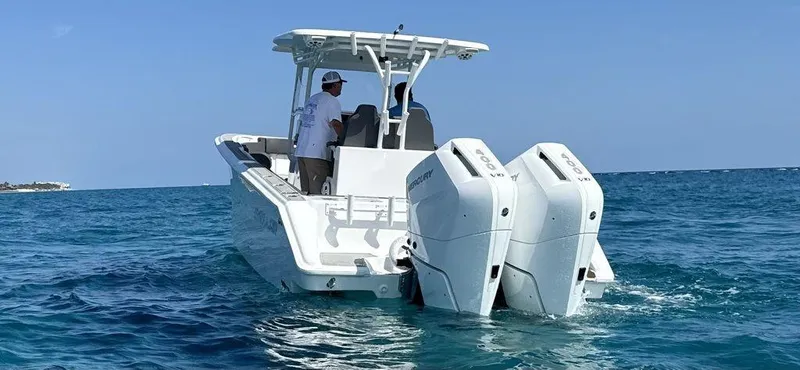Slide: The Image of 2024 Custom 335 boat with dual outboard engines on open water. - 14