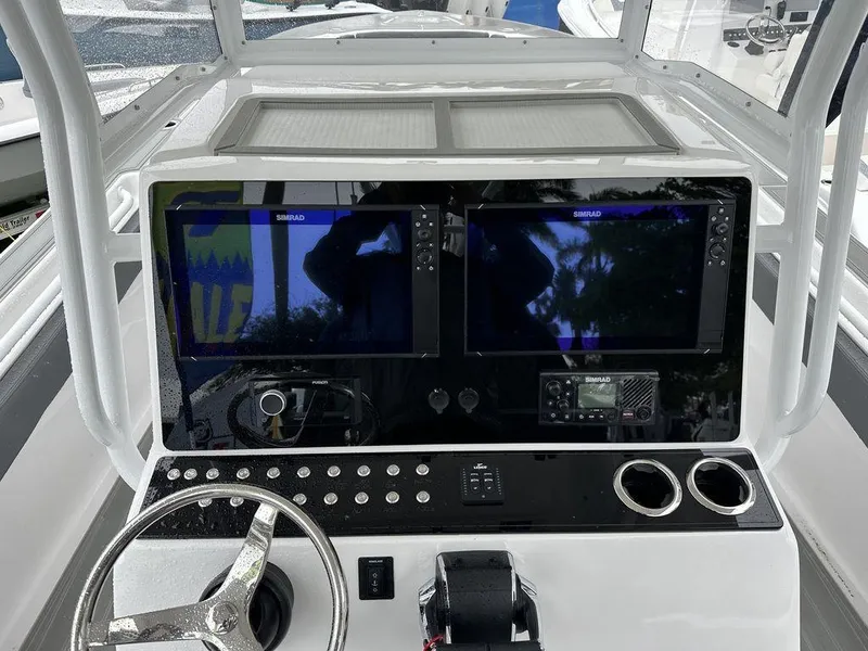 Slide: The Image of 2024 Custom 335 boat dashboard with dual Simrad displays and steering wheel. - 3