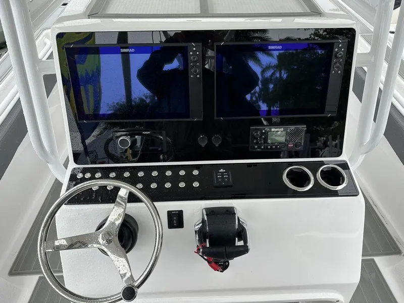 Slide: The Image of 2024 Custom 335 boat dashboard with dual Simrad displays and steering wheel. - 5