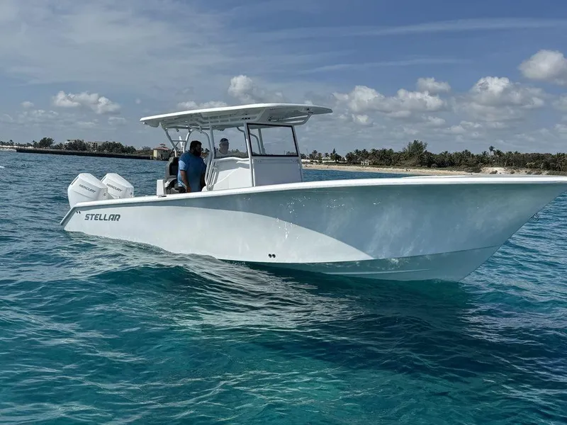 Slide: The Image of 2024 Custom 335 boat cruising on clear blue water near a tropical shoreline. - 8