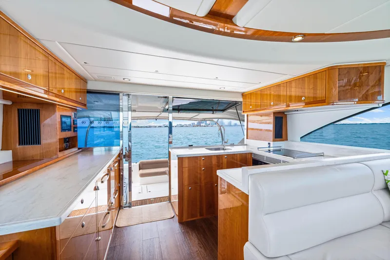 Slide: The Image of Interior of 2017 Riviera 575 SUV yacht with ocean view, featuring luxurious wood finishes and modern design. - 34