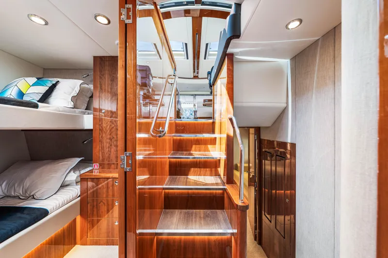 Slide: The Image of Interior of 2017 Riviera 575 SUV yacht with wooden stairs and cozy sleeping area. - 39