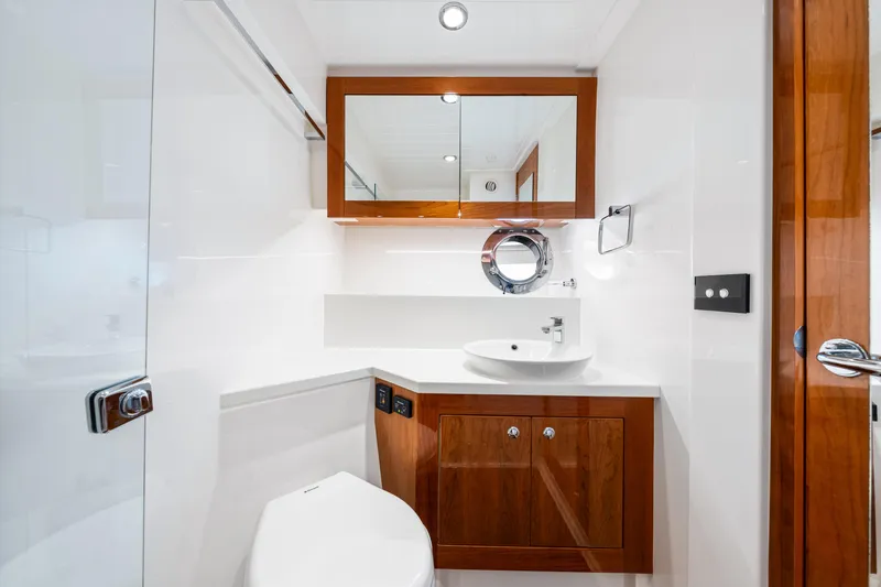 Slide: The Image of Modern bathroom in 2017 Riviera 575 SUV yacht with wooden cabinetry and white fixtures. - 45