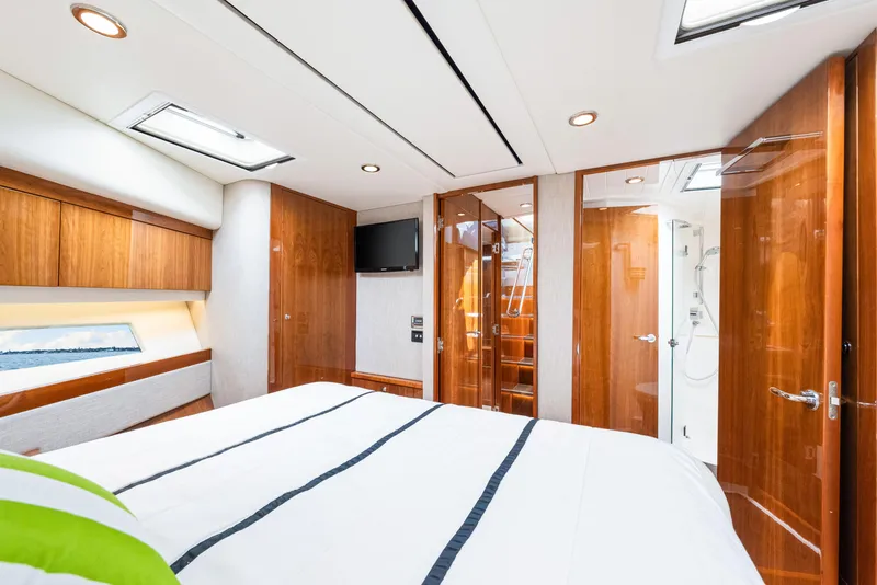 Slide: The Image of Luxurious interior of 2017 Riviera 575 SUV yacht bedroom with wood finishes and modern amenities. - 49