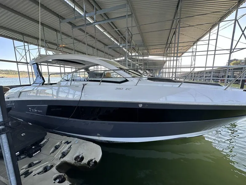 Slide: The Image of 2021 Cruisers Yachts 39 Express Coupe docked in a marina under a covered structure. - 2