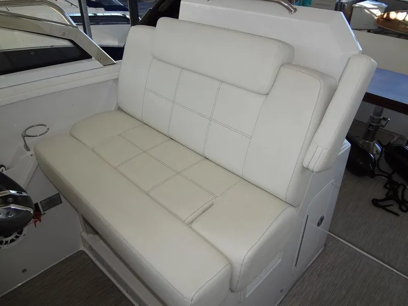 Slide: The Image of 2021 Cruisers Yachts 39 Express Coupe interior seating with wooden footrest. - 41