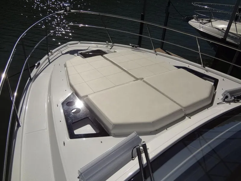 Slide: The Image of 2021 Cruisers Yachts 39 Express Coupe bow with sunpad, docked on calm water. - 48