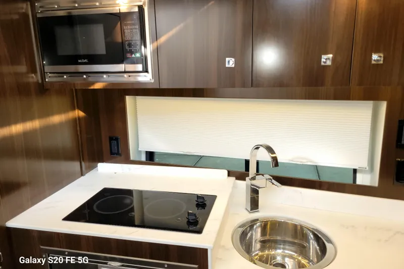 Slide: The Image of Modern kitchen in 2021 Cruisers Yachts 39 Express Coupe with stove, sink, and microwave. - 63