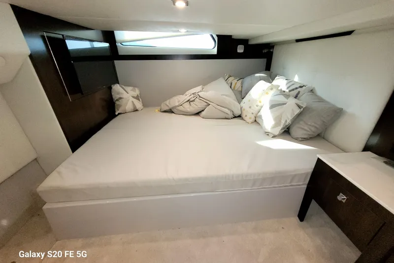 Slide: The Image of 2021 Cruisers Yachts 39 Express Coupe cabin with cozy bed and modern decor. - 64