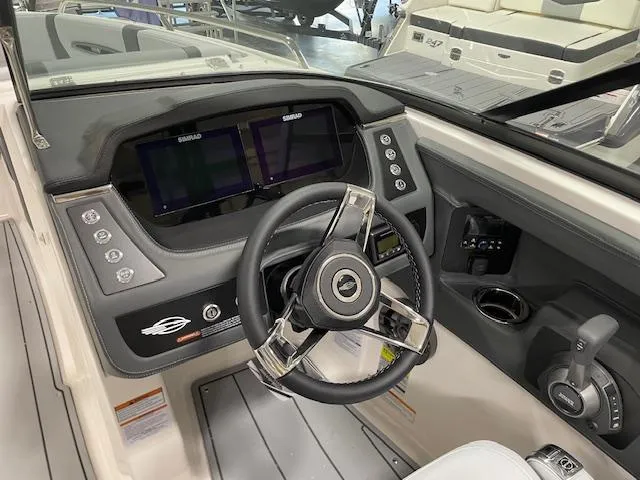 Slide: The Image of 2025 Chaparral 247 SSX boat dashboard with modern steering wheel and digital displays. - 14