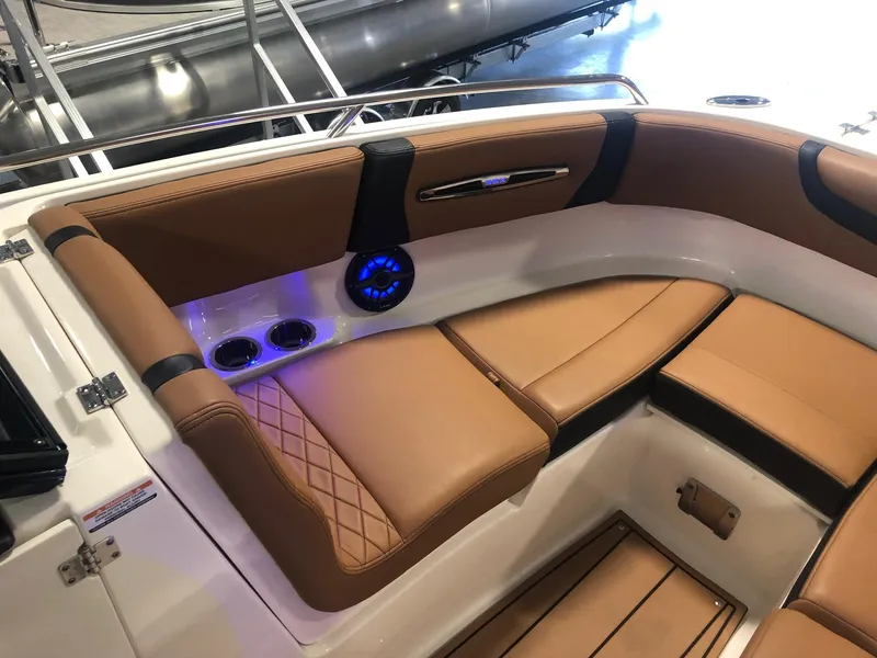 Slide: The Image of Luxurious seating area of the 2024 Chaparral 247 SSX boat with tan upholstery and blue LED lighting. - 14