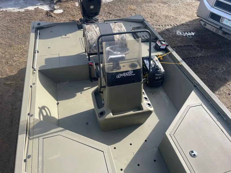 Slide: The Image of 2024 Tracker Grizzly 2072 CC Sportsman boat interior with center console and camo seats. - 12